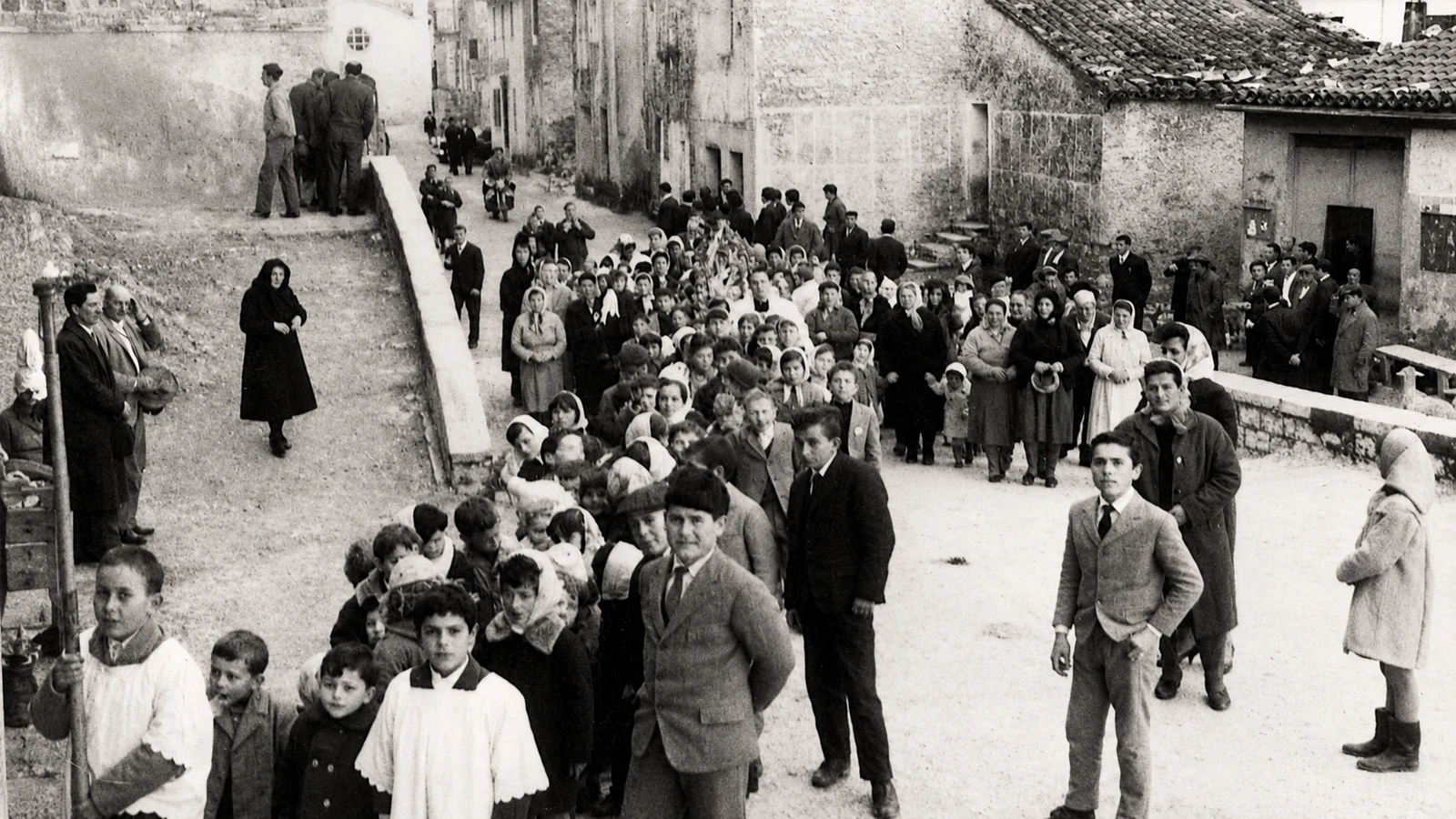 Processione storica della Festa della Madonna della Speranza lungo una strada di Castelletta, con gli abitanti riuniti tra le case in pietra.